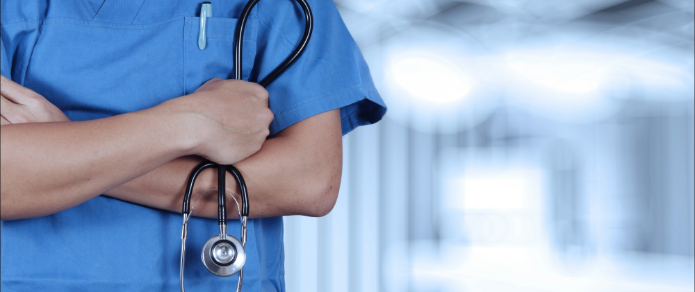 Pflegefachperson mit Stethoskop in einem Schweizer Klinik-Setting.